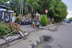 Warga Kota Metro Keluhkan Tiang Papan Bunga yang Tergeletak di Trotoar